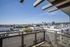Modern apartment balcony with breathtaking city skyline views and clear blue skies, creating a serene urban oasis.
