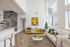 Bright modern living room featuring high ceilings, large windows, a spiral staircase, and stylish decor for a sophisticated urban lifestyle.