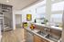 Bright and modern loft apartment featuring a sleek spiral staircase, open kitchen with granite countertops, and a cozy living area with large windows and city views.