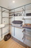 Modern walk-in closet with sleek metal shelving and ample storage space, featuring hangers, pillows, and organized bins.