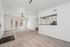 Bright and spacious living room with plush carpeting, modern ceiling fan, and large windows offering ample natural light.