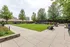 Luxurious outdoor patio with lush green lawns, comfortable seating, and vibrant garden surrounded by mature trees, perfect for relaxation and gatherings.