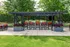 Chic outdoor patio area with modern pergola, vibrant garden seating, and lush greenery, perfect for relaxed outdoor gatherings.