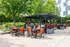 Vibrant outdoor patio with modern seating and BBQ area, surrounded by lush greenery and elegant landscaping.