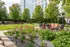 Charming outdoor lounge in lush garden setting with modern seating and vibrant flowers, perfect for relaxation and gatherings.