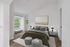 Bright, inviting bedroom with elegant decor, featuring a large window, plush carpet, and modern furnishings. Perfect for relaxation.