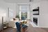 Bright and inviting living room with large windows, modern furniture, and a cozy fireplace.