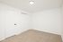 Bright and inviting empty room with plush carpeting and sleek white walls, showcasing a modern lighting fixture.