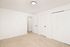 Bright, spacious room featuring plush carpet flooring, modern white walls, and elegant black door handles, ideal for a cozy bedroom or office space.