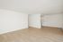 Bright and spacious open-concept living area with sleek wood flooring and modern kitchen.