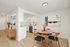 Modern apartment with open kitchen and dining area featuring sleek white cabinets, stylish wood furniture, and contemporary art.