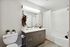 Modern bathroom featuring elegant vanity, chic decor accents, and a stylish patterned shower curtain.
