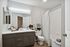Elegant bathroom with modern vanity, sleek lighting, and a stylish shower area featuring chic patterned curtains.
