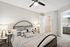 Serene bedroom with chic decor, cozy bed, modern ceiling fan, and an inviting walk-in closet, offering a tranquil retreat.