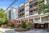 Charming apartment building with a modern facade, lush landscaping, and welcoming entrance, perfect for luxurious urban living.