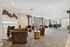 Elegant and spacious modern lounge area with cozy seating, a warm fireplace, and large windows offering natural light.