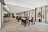 Elegant open-concept living space featuring modern dining area with stylish chairs, plush sofas, and expansive windows for natural light.