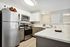 Modern kitchen with sleek stainless steel appliances, elegant white cabinetry, and chic marble countertops, creating a sophisticated cooking space.