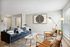 Chic modern living room with stylish navy sofa, geometric decor, and floor-to-ceiling windows for natural light.