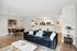 Bright and modern living space with a cozy velvet sofa, elegant dining area, and a sleek open kitchen design.