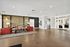 Inviting apartment lobby with modern wood accents, stylish red armchairs, and a cozy seating area.