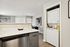 Chic apartment interior featuring a sleek kitchen with modern appliances and a convenient in-unit laundry area.