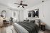 Elegant modern bedroom with a stylish design, featuring a cozy bed, chic wall art, and abundant natural light through large windows.
