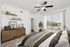 Elegant bedroom with a stylish ceiling fan, large window, and lush greenery for a cozy, inviting atmosphere.