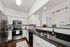 Chic kitchen with sleek stainless steel appliances, elegant white cabinetry, and a stylish dark granite countertop, perfect for modern living.