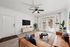 Inviting modern living room with a cozy leather sofa, elegant decor, chic coffee table, and refreshing greenery accentuated by natural light from wide French doors.