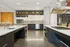 Elegant modern kitchen featuring sleek countertops, high-end appliances, and stylish open shelving, perfect for culinary enthusiasts.