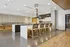 Modern kitchen with sleek island, high-backed stools, and minimalist decor, perfect for entertaining.