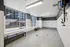 Modern pet washing station with benches, large windows, and sleek fixtures in a stylish apartment building.