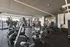 Modern fitness center with state-of-the-art equipment including exercise bikes, weight machines, and ample space for workout routines.
