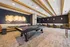 Modern recreational room featuring a sleek black pool table, elegant overhead lighting, and a cozy seating area with chic decor.