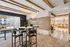 Modern apartment interior featuring a cozy dining area with stylish wood accents and a sleek fireplace, adjacent to a bright kitchen with elegant lighting.