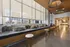 Modern lounge area filled with comfortable seating, stylish wooden accents, and ample natural light from large windows.