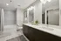 Elegant modern bathroom with a double vanity, stylish lighting, and a relaxing bathtub in a pristine white and gray color scheme.