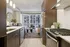 Modern kitchen with sleek stainless steel appliances and cozy living area with ample natural light and stylish decor.