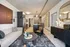 Modern apartment living room with sleek decor, featuring a cozy sofa, stylish artwork, and a chic kitchen in the background.