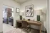 Chic apartment featuring a stylish workspace with modern decor, elegant wooden desk, and a view into a sleek, contemporary kitchen.