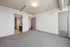 Modern apartment interior with polished concrete ceilings, neutral-toned walls, and a sleek bathroom entrance.
