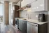 Modern kitchen with sleek cabinetry, stainless steel appliances, and a chic geometric backsplash, perfect for culinary enthusiasts.