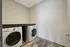 Modern laundry room featuring sleek Whirlpool washer and dryer, complemented by stylish wood flooring and neutral walls.