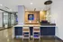 Modern apartment lobby with chic wooden accents, stylish bar seating, and ambient lighting.