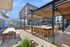 Modern outdoor patio with sleek pergola and stylish seating, perfect for entertaining in a vibrant apartment community.