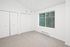 Bright, inviting room with soft carpet, large window, and spacious closets, perfect for a serene retreat.