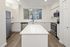 Modern kitchen design featuring sleek white cabinetry, elegant countertops, and stainless steel appliances complemented by natural light.