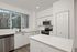 Modern kitchen with sleek white cabinetry, stainless steel appliances, and a spacious island offering a bright and inviting cooking space.