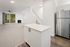 Modern open-space living area with sleek kitchen island, cozy fireplace, and large window offering a scenic view.